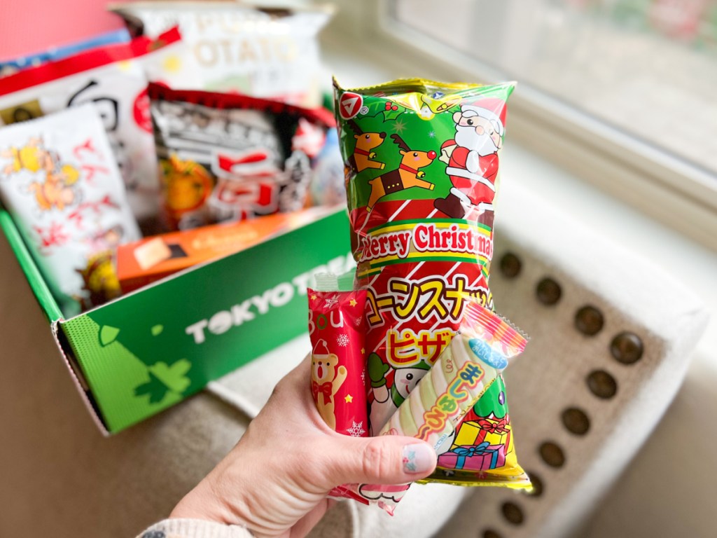 hand holding christmas snacks in front of treat box