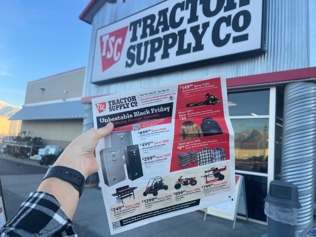 hand holding up a tractor supply black friday ad outside the store
