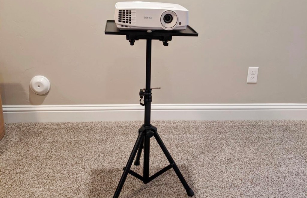 black tripod with white projector on top