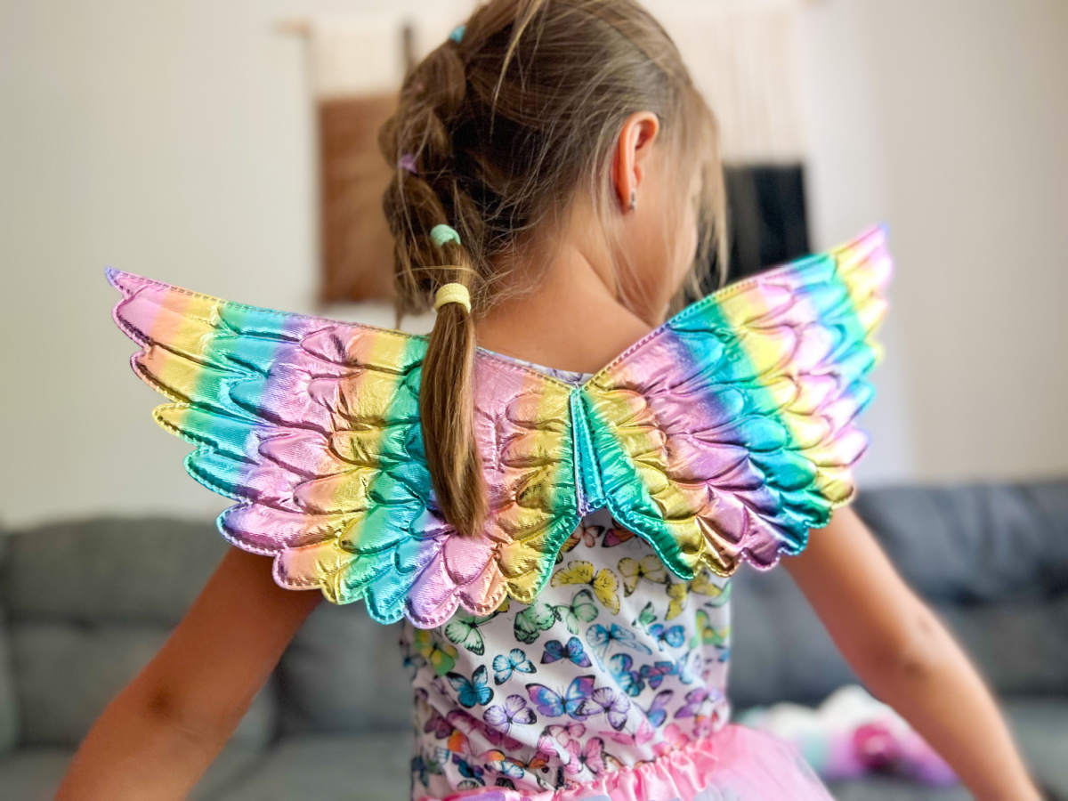 young girl wearing colorful unicorn wings