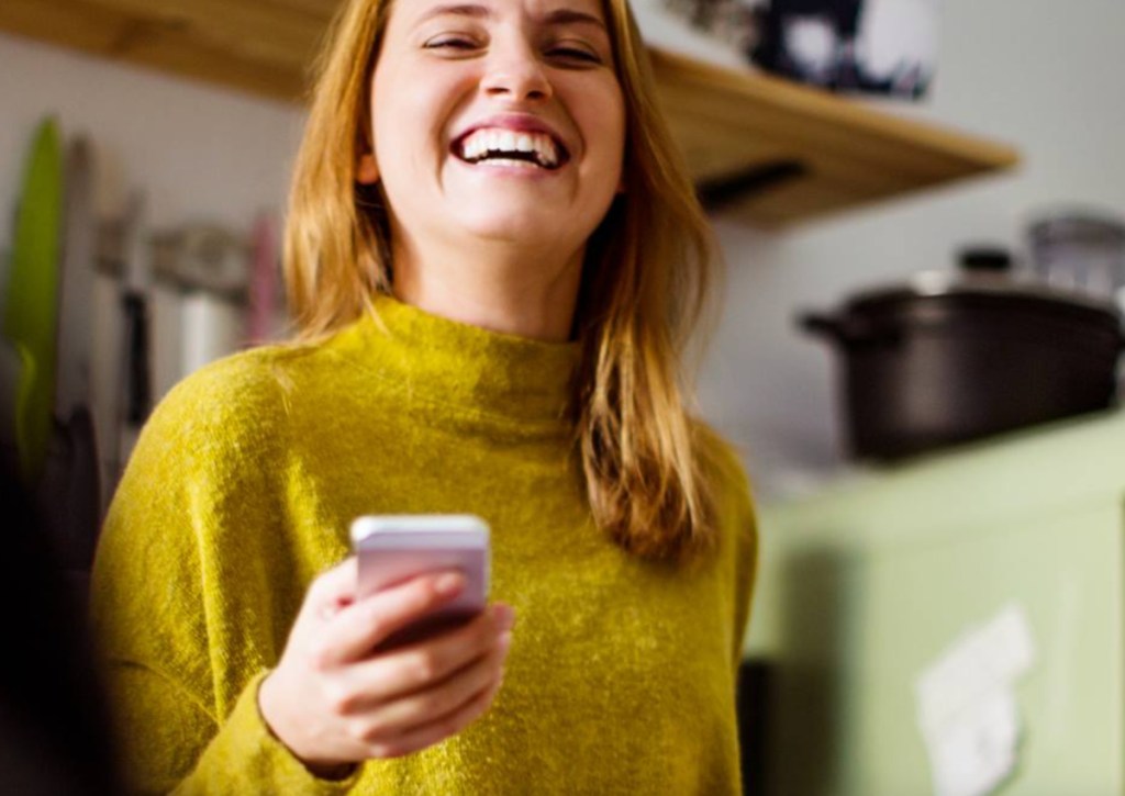 woman smiling holding phone