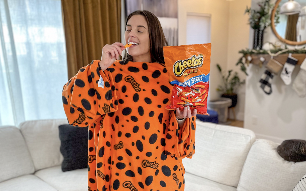woman wearing Cheetos snuggie while eating Cheetos 
