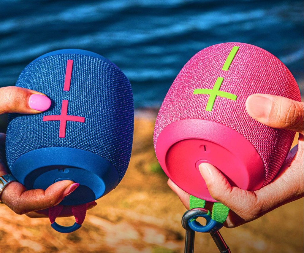 two colorful wireless speakers in hands