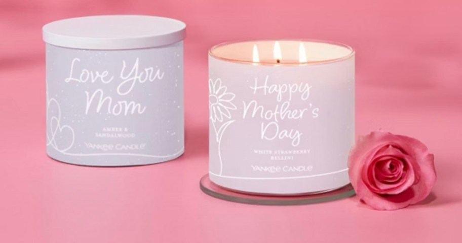 two 3 wick mothers day candles on table with rose