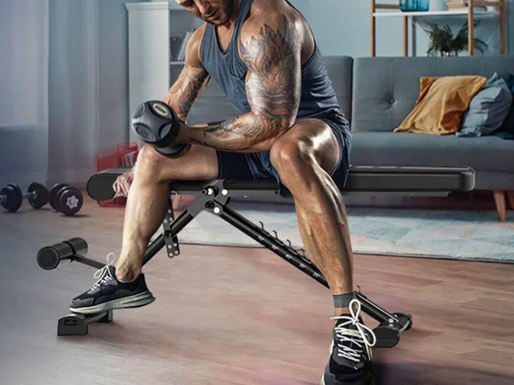 man sitting on and working out with a Thramono Adjustable Weight Bench