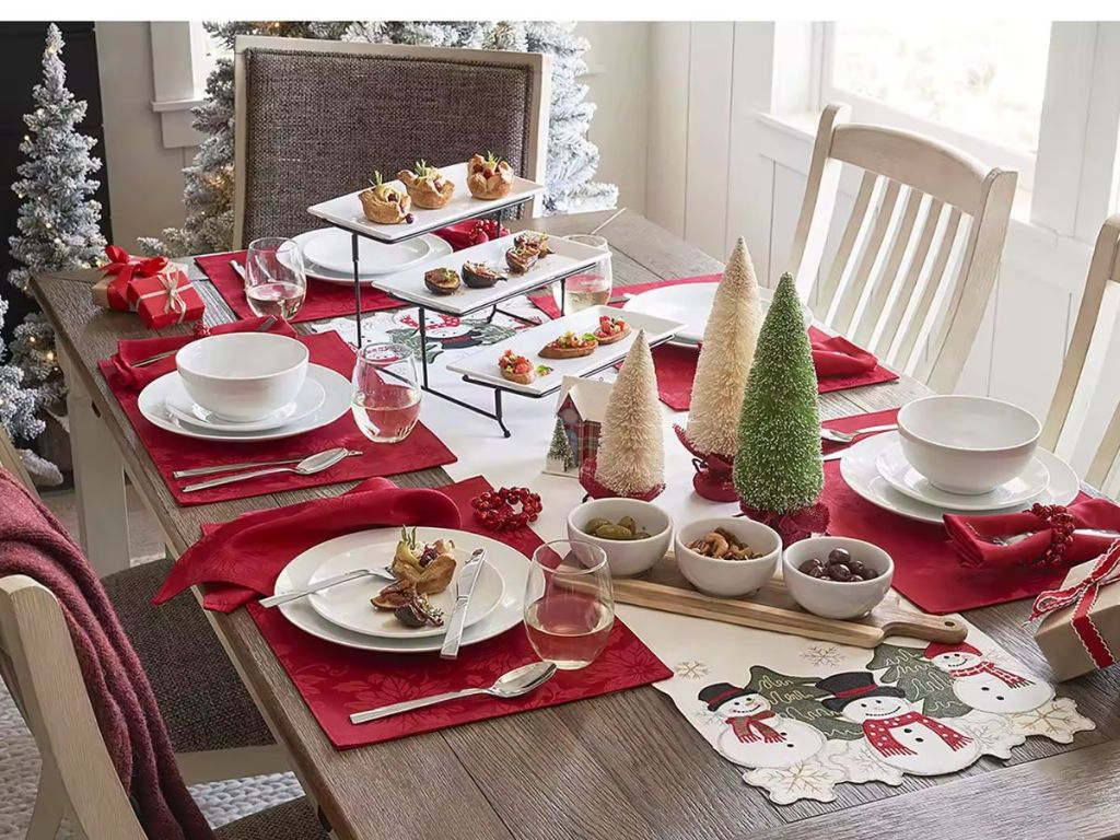 dining room table set with Christmas linens and dinner plates and decor