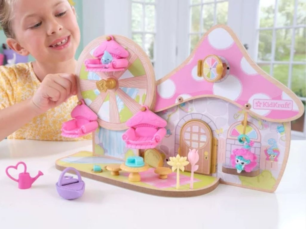 little girl playing with a KidKraft Lil Green World Wooden Fairy Cottage and Ferris Wheel Play Set 