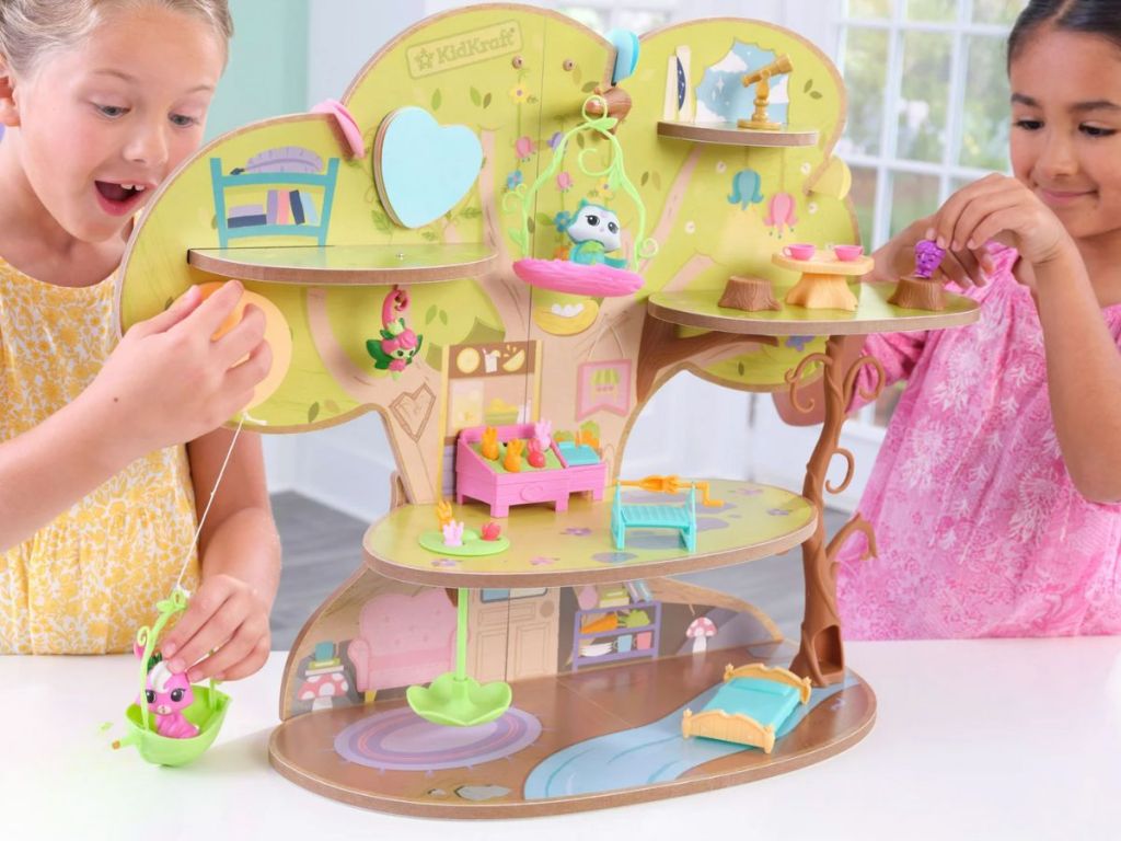 little girls playing with a KidKraft Lil Green World Wooden Market Treehouse Play Set 