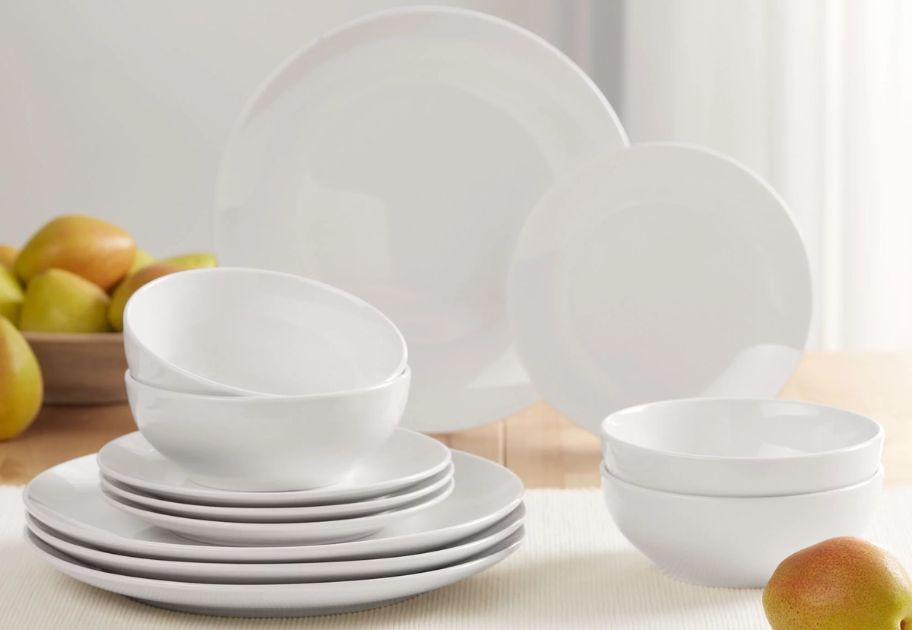 set of 12 glazed white dinnerware pieces on a table