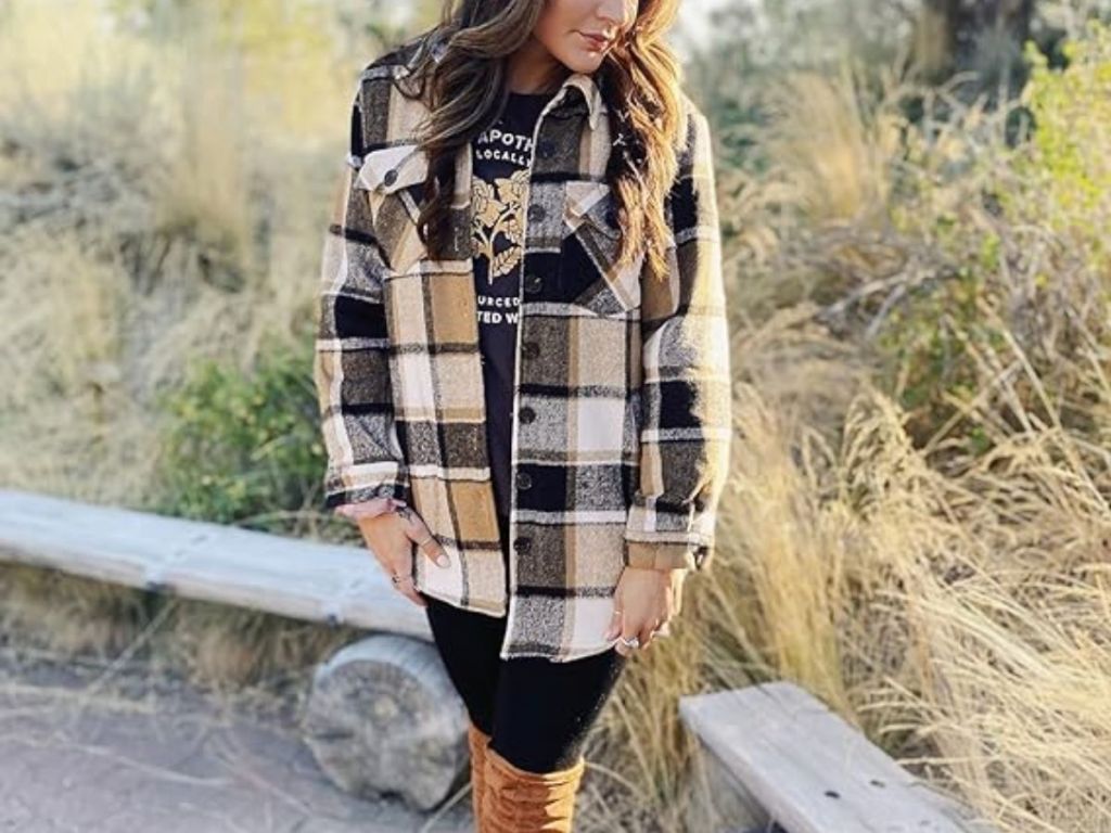 woman wearing a tan and black shacket standing outside