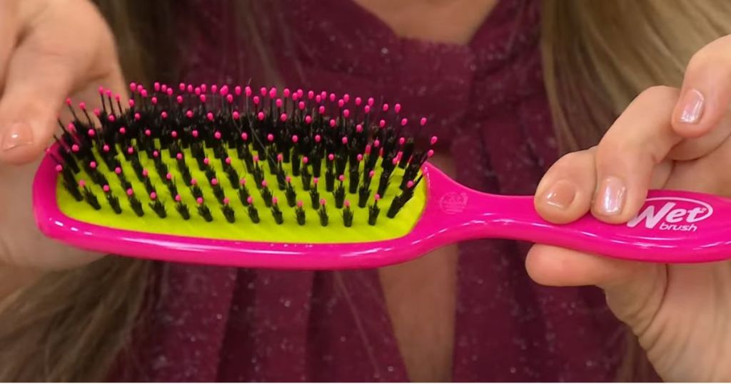 woman holding a hot pink Wet Brush Shine Enhancer Brush 