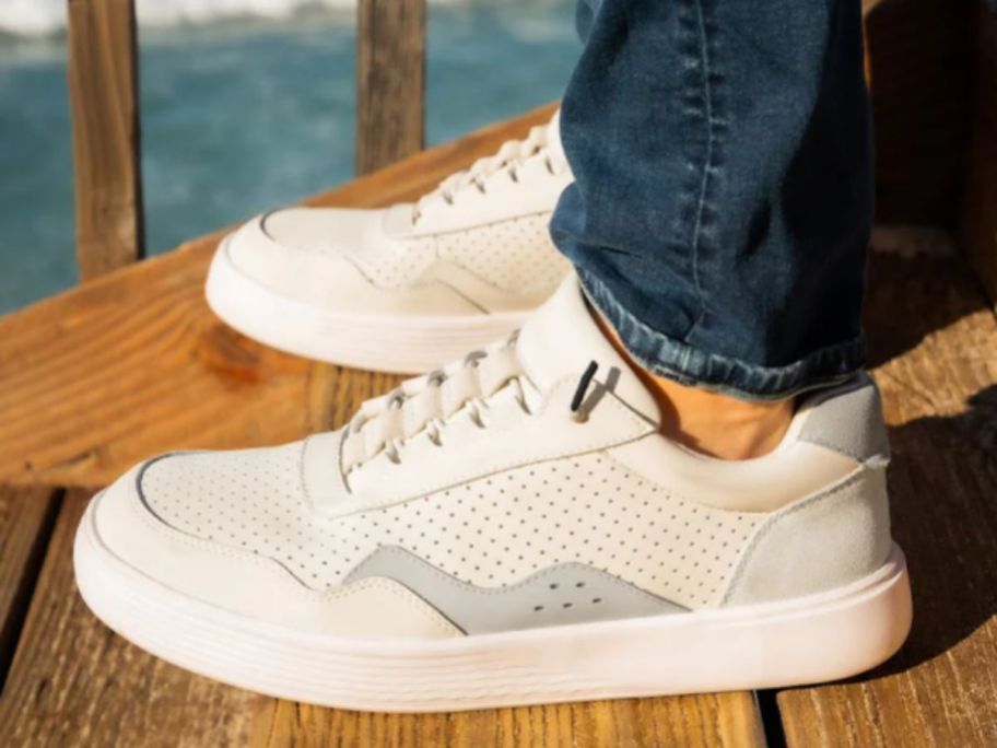 man's feet wearing a pair of white HEYDUDE Hudson Canvas sneakers