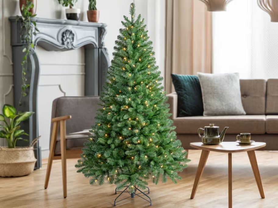 a green artificial Christmas tree with clear lights in a living room