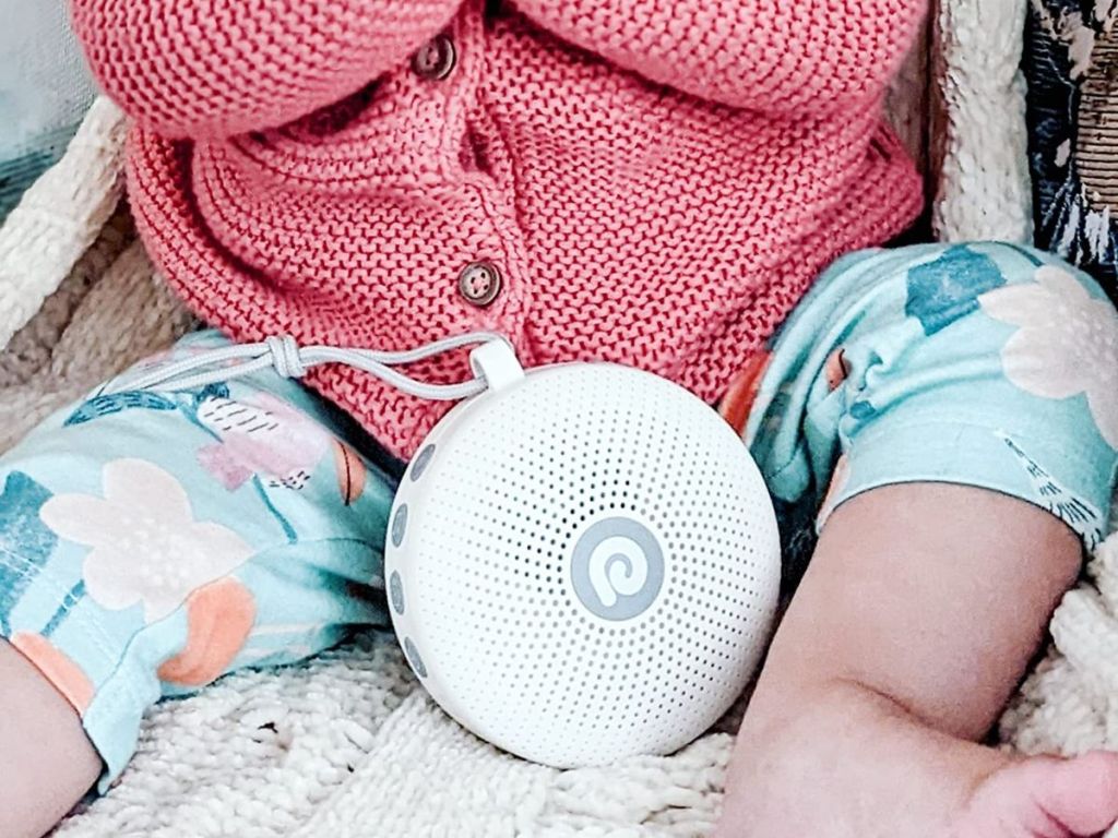 Baby sitting with a Dreamegg D11 Portable White Noise Sound Machine for Babies and Adults