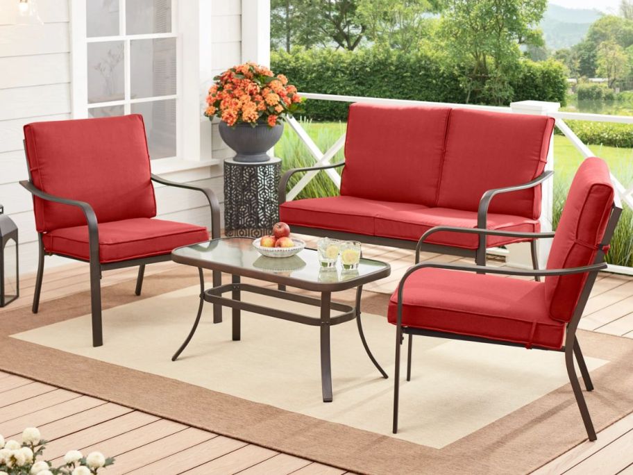 metal patio furniture set with red cushions on deck