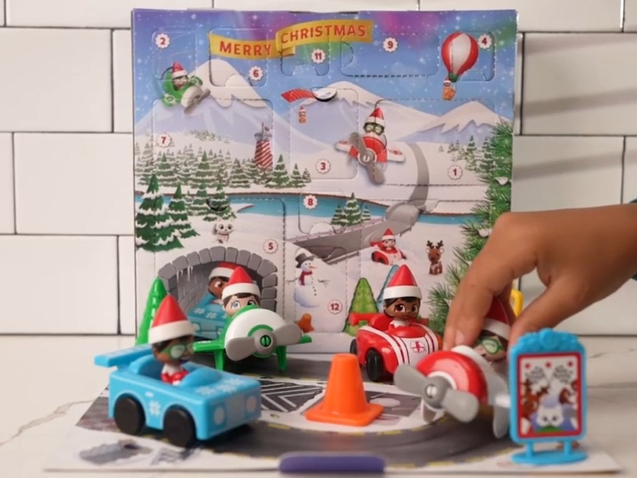 kid playing with an Elf on The Shelf Spin & Soar 12-Day Countdown with toy roadway and vehicle rides