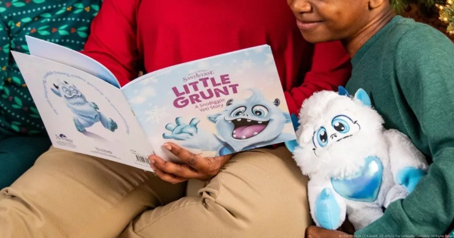 parent reading an Elf on The Shelf Little Grunt book to kids, little boy holding a plush Little Grunt toy