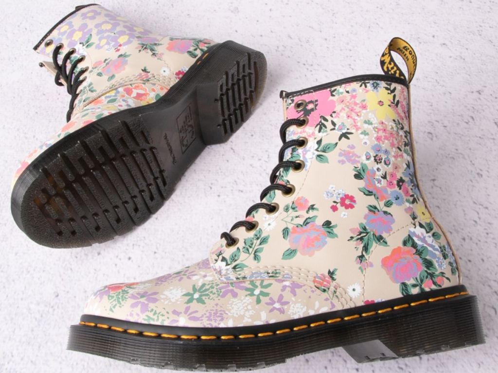 pair of tan Dr. Marten's boots with different color flowers on them