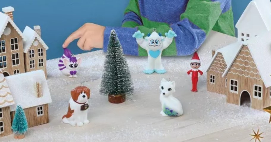 5 different Elf on The Shelf Santaverse ornaments being used as mini toy figures