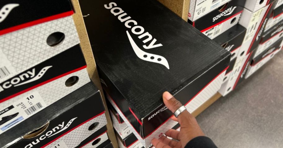 Hand pulling a saucony Shoe Box off a shelf