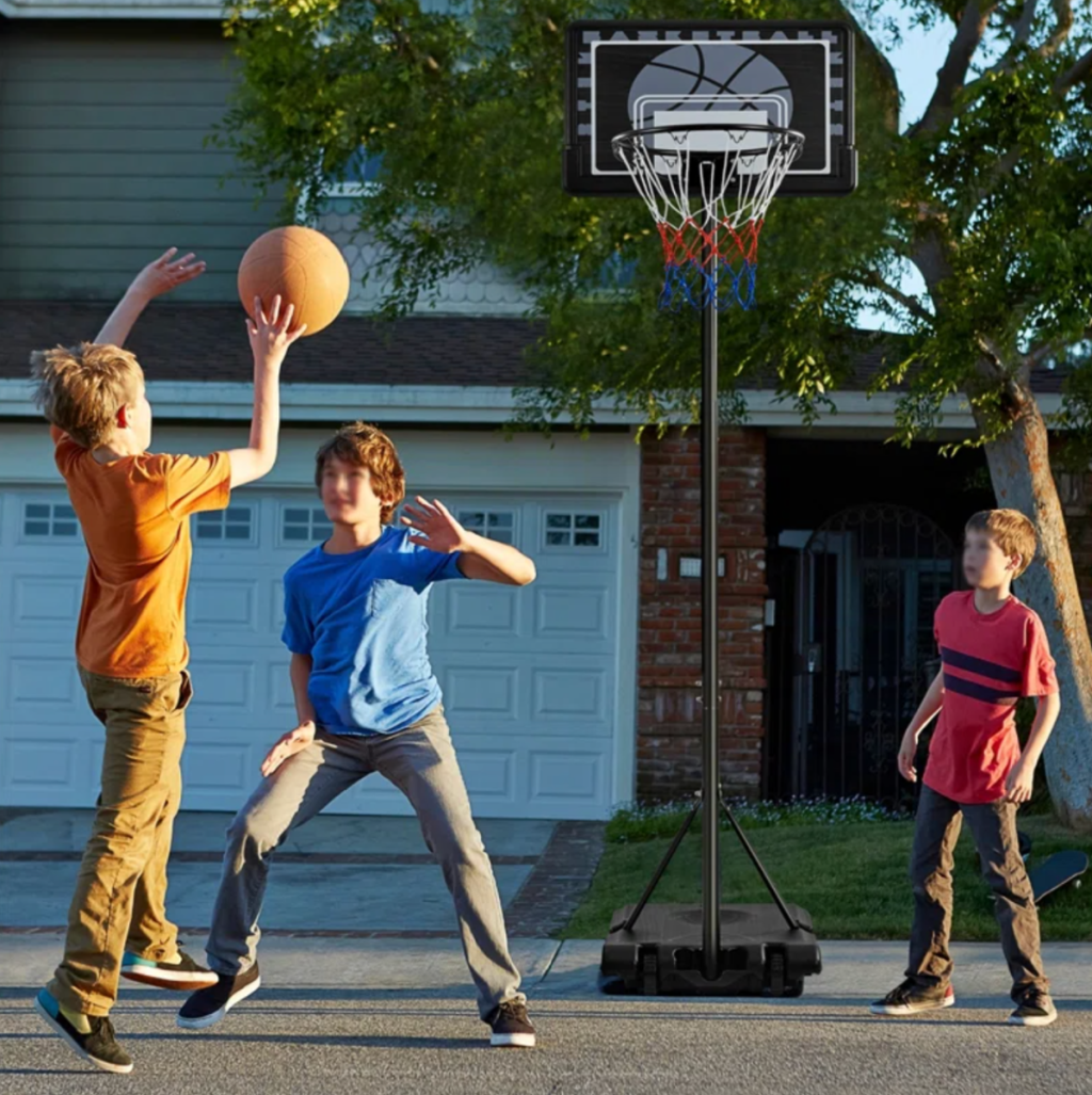 Kids playing basketball with an adjustable height basketball hoop from Wayfair