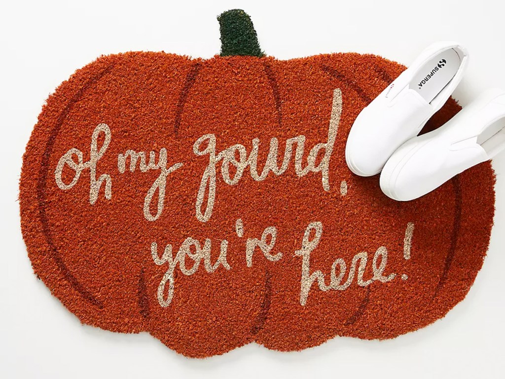 pumpkin shaped doormat that says "oh my gourd, you're here!"