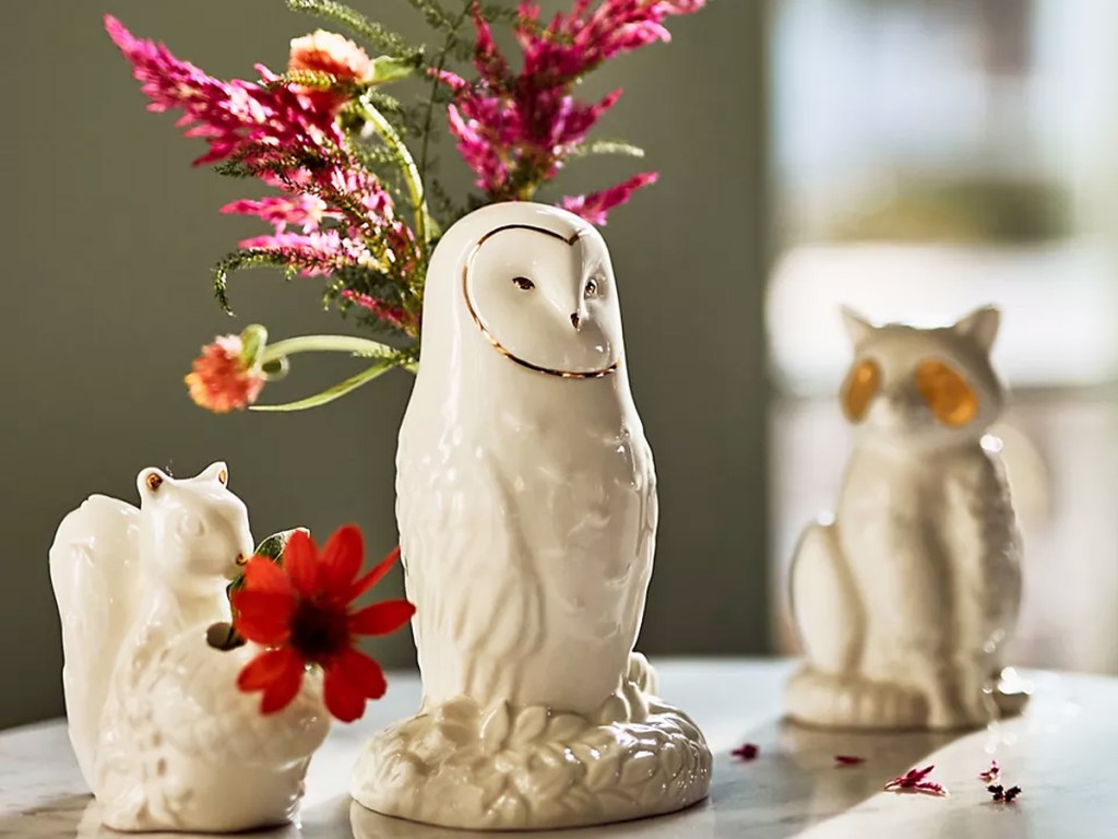 white and gold owl vase with pink flowers inside