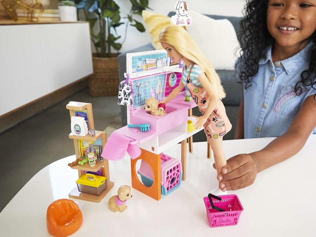 girl playing with Barbie Doll and Pet Boutique Playset