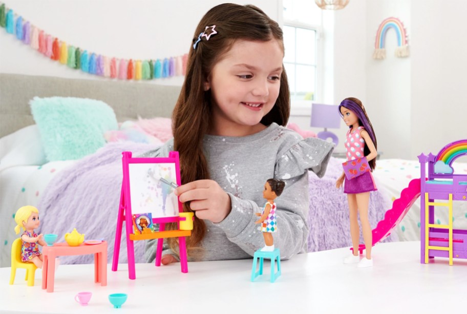 girl playing with barbie daycare playset