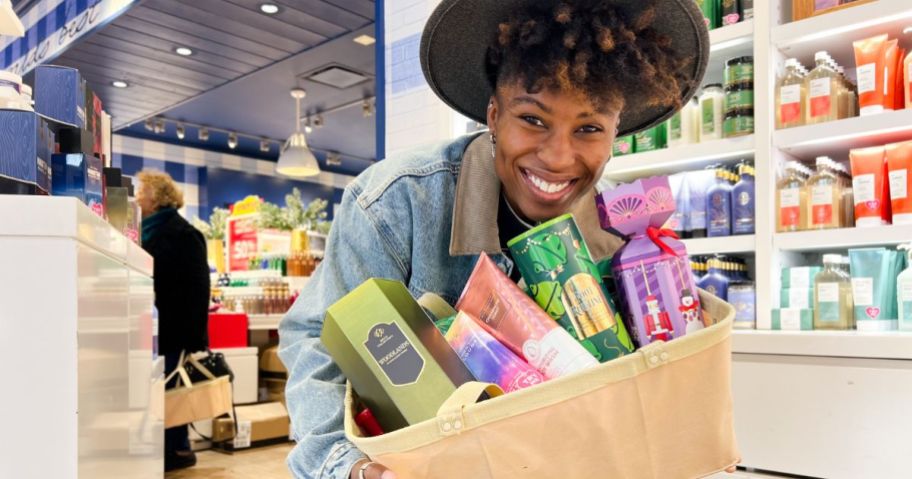 Woman holding basket with bath & body works items inside of them