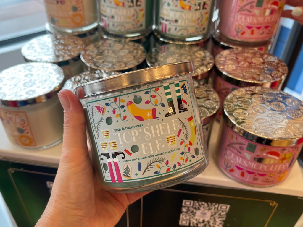 person holding Bath & Body Works Top Shelf Elf Candle