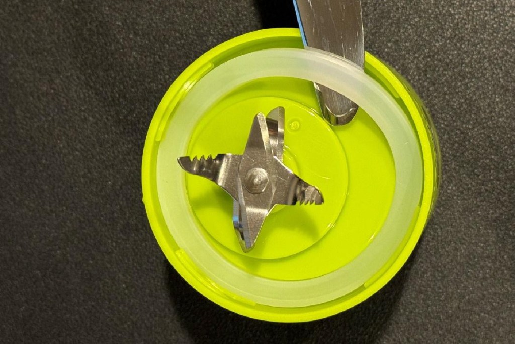 Using a knife to remove the rim of the BlendJet 2 Portable Blender base