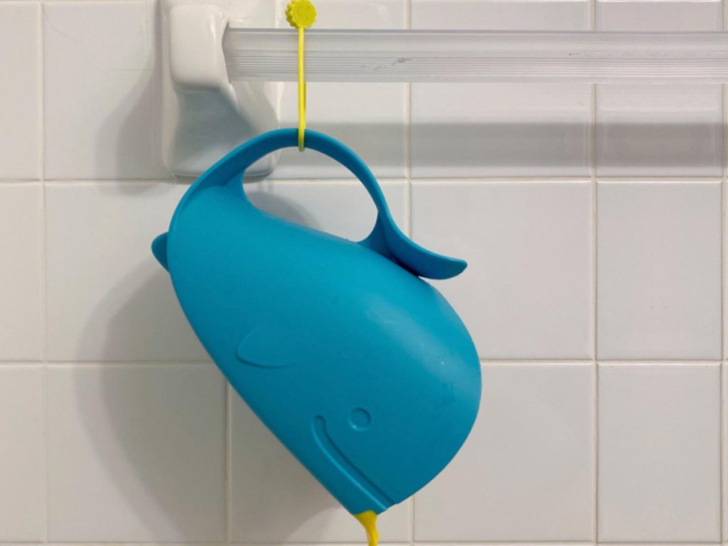 Yellow silicone tie, holding up blue bath toy on towel bar