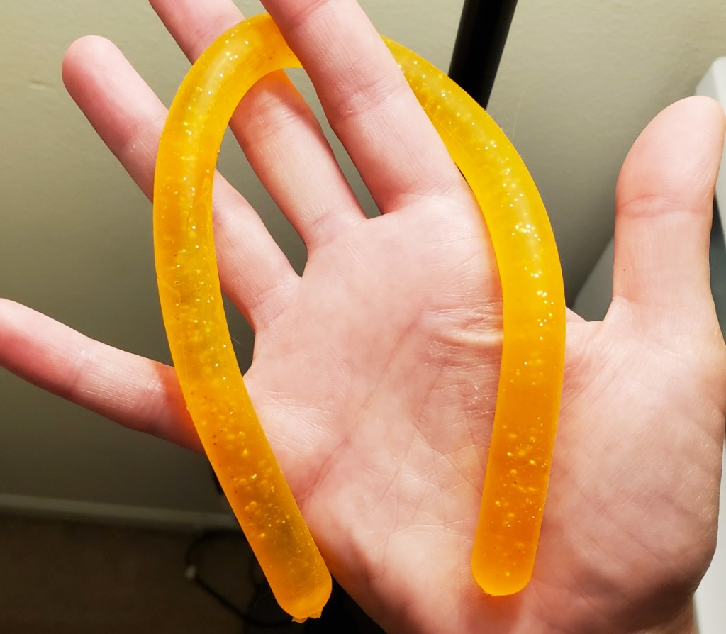 hand holding an orange glitter stretchy string