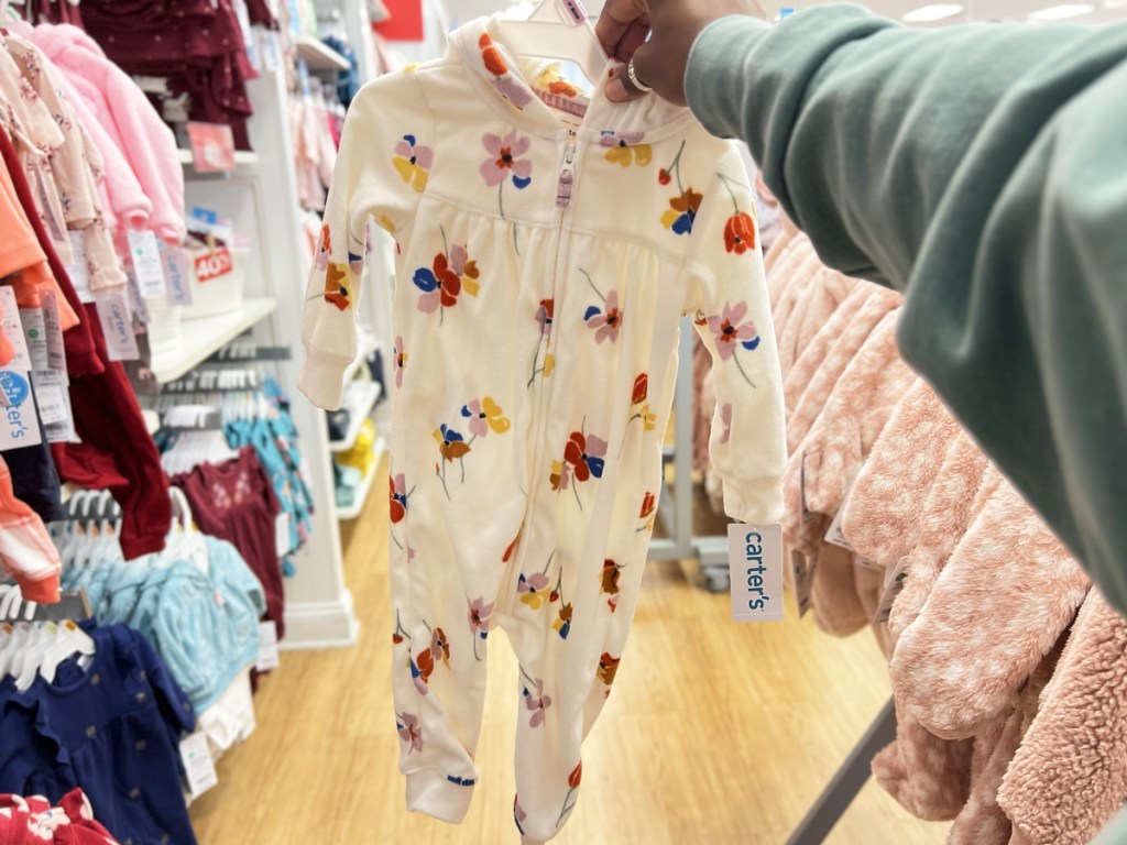 hand holding up floral print baby pajamas