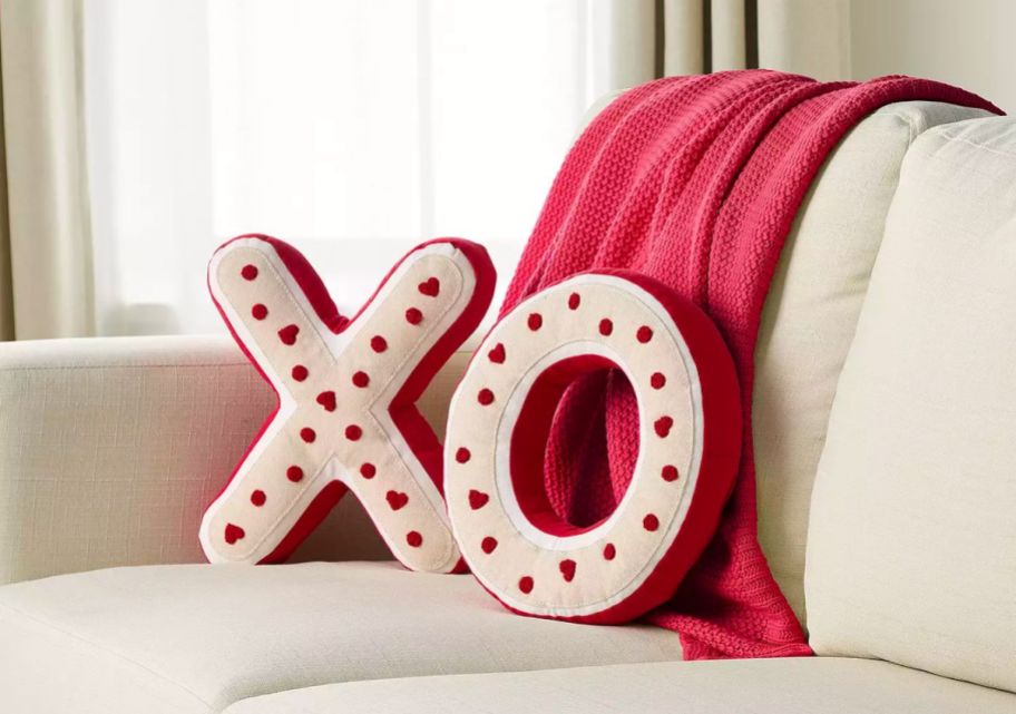 two pillows on a sofa - one shaped like an X and one shaped like an O
