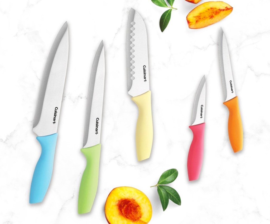 set of Cuisinart kitchen knives with colorful handles near sliced peach