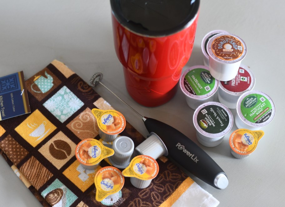 A coffee themed tumbler gift with items like k-pods and coffee themed dish towels