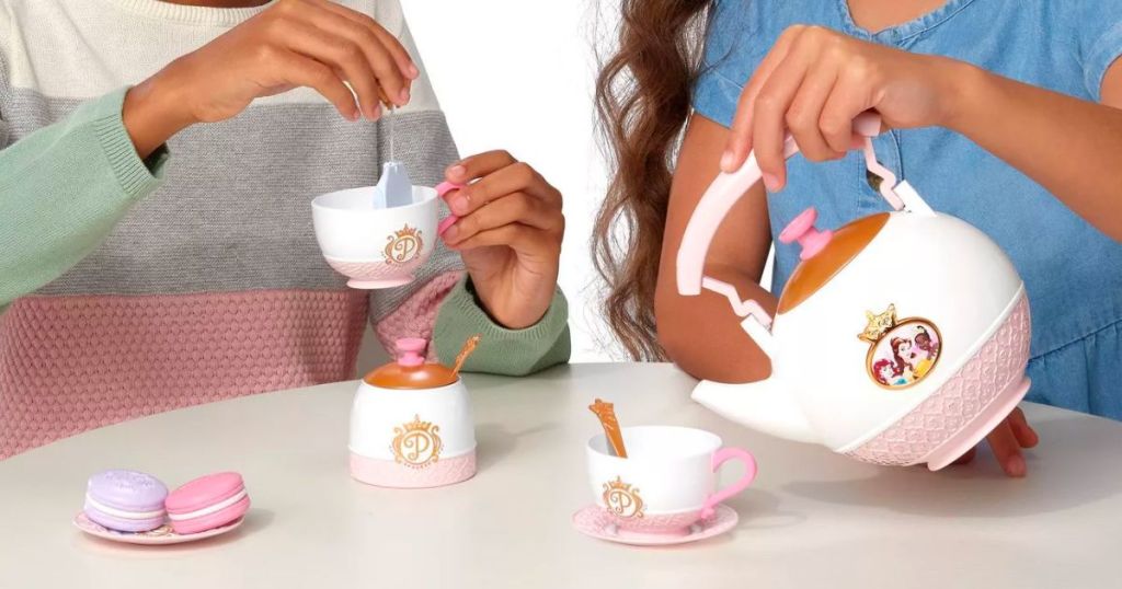 two little girls playing with a Disney princess style tea set