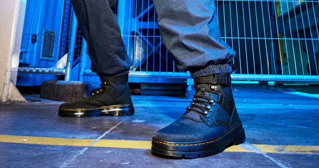 man wearing black lace-up boots with buckle at the top