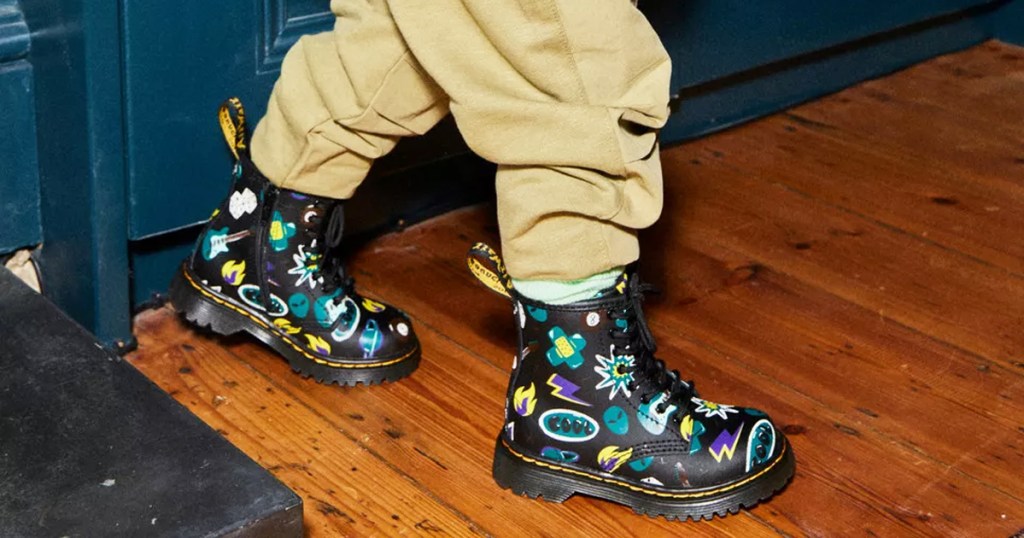 boy wearing black lace up boots with doodle print