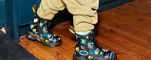 boy wearing black lace up boots with doodle print