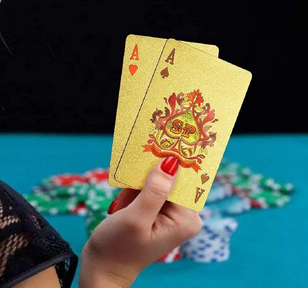 hand holding up two EAY gold playing cards