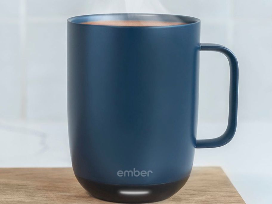 A blue Ember mug on a cutting board