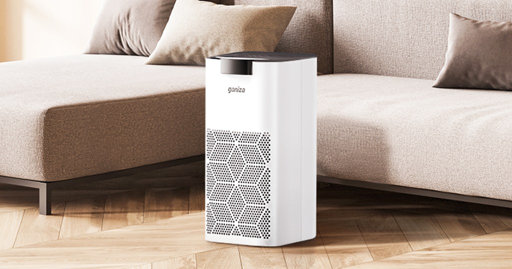 white air purifier on floor in front of couch