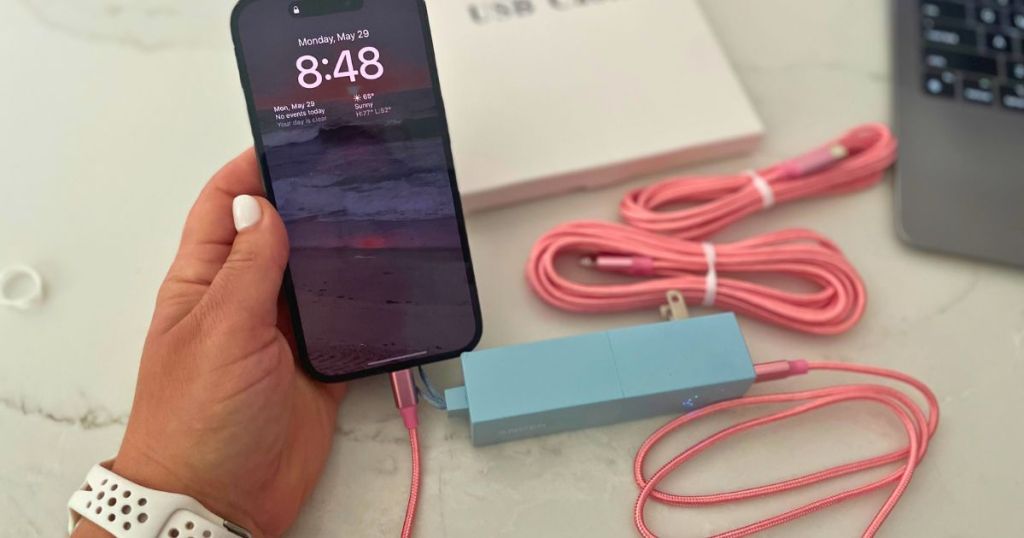 Firsting iphone Charging cables connected to phone in woman's hand