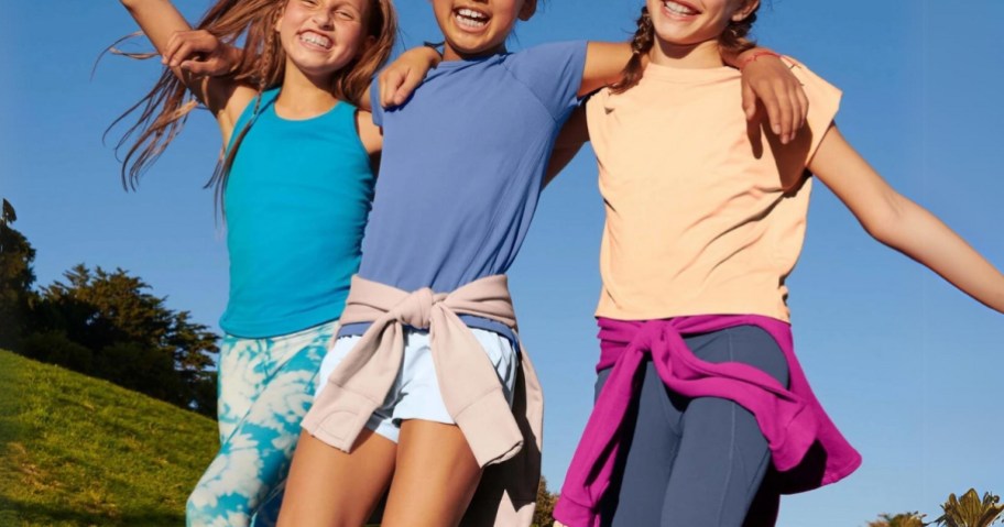 3 tween girl's wearing colurful Athleta Girl clothing outside