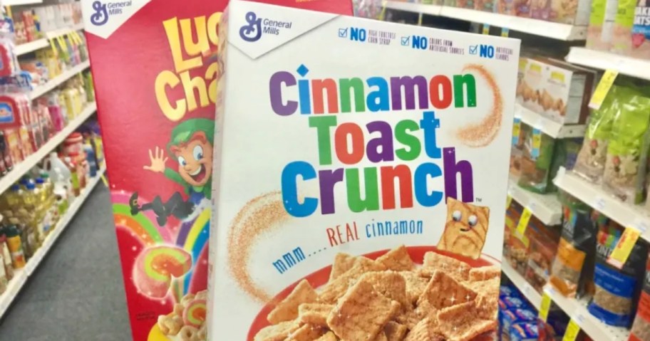 hand holding boxes of cinnamon toast crunch and lucky charms