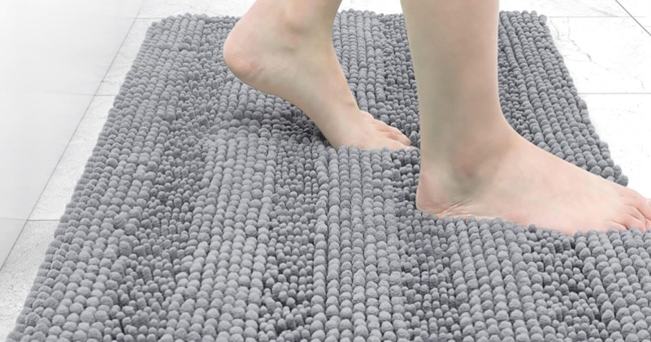 woman's bare feet stepping onto a gray chenille bubble baht mat