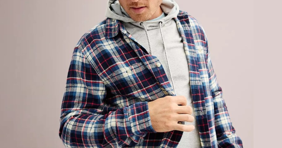 man wearing a blue and red flannel shirt with a light grey hoodie underneath